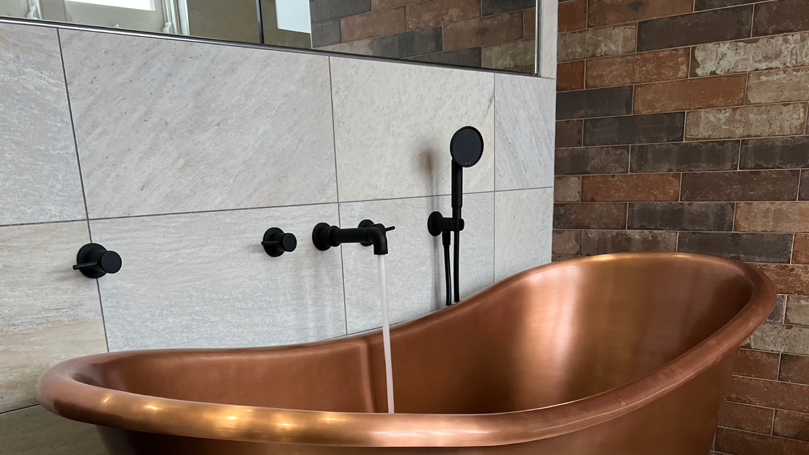 Bespoke copper bath installation in luxury bathroom